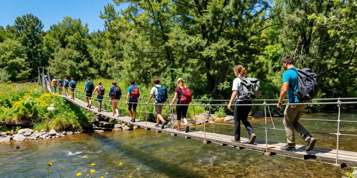 Group crossing a sturdy River Rope Bridge in a lush forest, showcasing outdoor adventure.